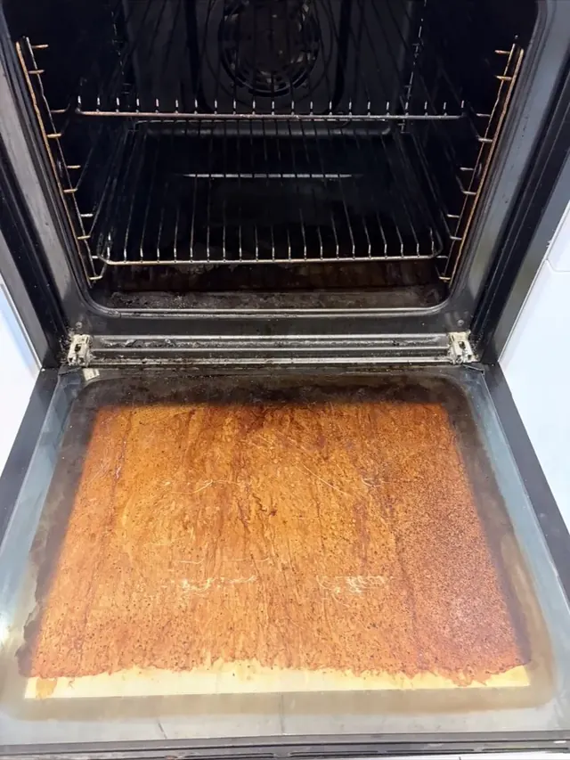 Oven base covered in thick burnt-on grease before professional oven cleaning